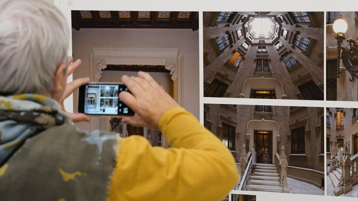 Una mujer fotografía uno de los paneles de la exposición, en una de las visitas guiadas.