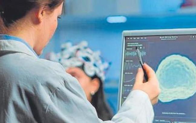 Un investigador realizando un escaneo cerebral. Un investigador realizando un escaneo cerebral.