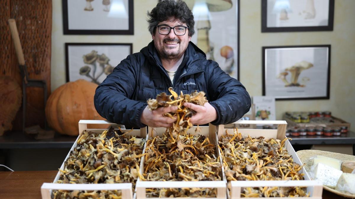 Tatxo Martínez posa junto a cajas repletas de setas en su tienda de la Rochapea.