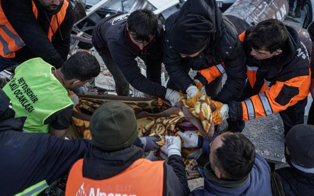 Un equipo de rescate cubre con una manta un cuerpo hallado bajo los escombros de un edificio en Antakya, Turquía. Un equipo de rescate cubre con una manta un cuerpo hallado bajo los escombros de un edificio en Antakya, Turquía.