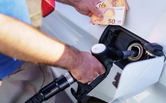 Un conductor reposta combustible en una gasolinera. Un conductor reposta combustible en una gasolinera.
