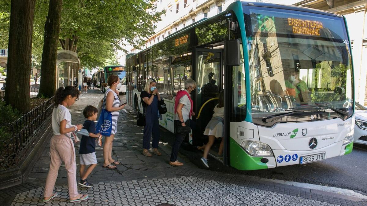 Varios usuarios de Lurraldebus suben a un autobús en la Plaza de Gipuzkoa de Donostia.