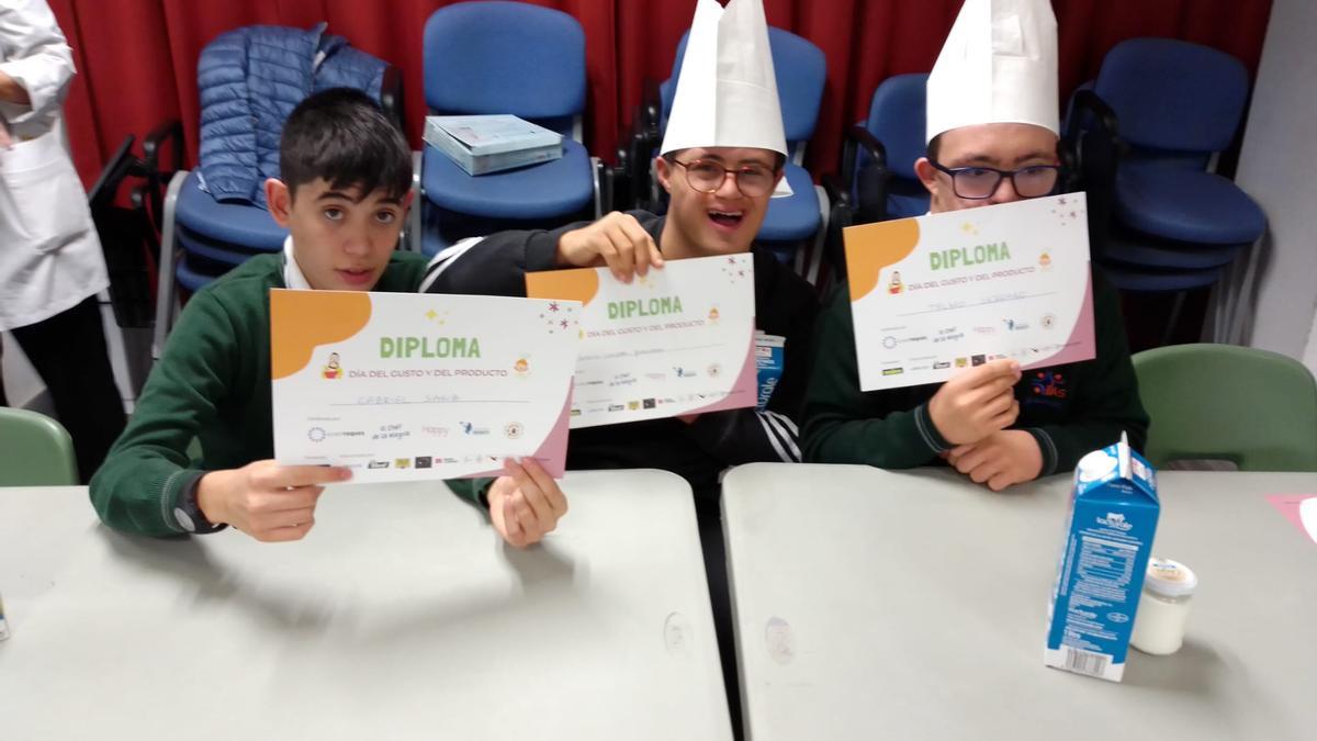 Los alumnos enseñan sus diplomas del Día del gusto y del producto.
