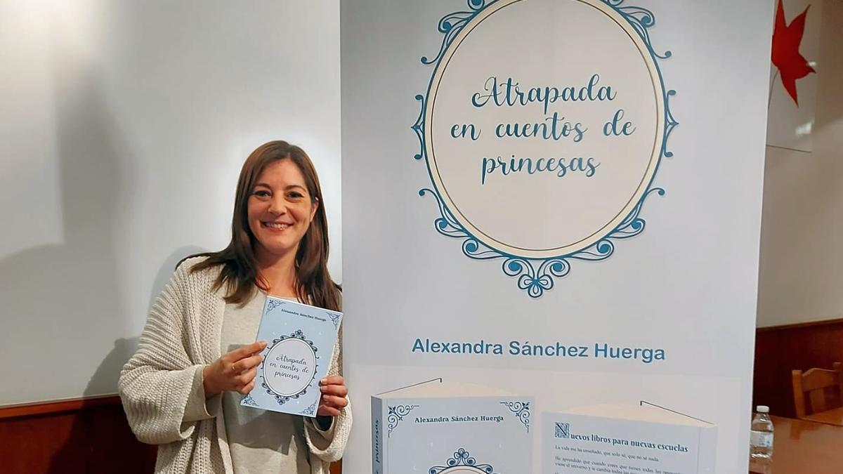 Alexandra posa ante el roller publicitario que anuncia su libro.