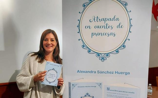 Alexandra posa ante el roller publicitario que anuncia su libro.
