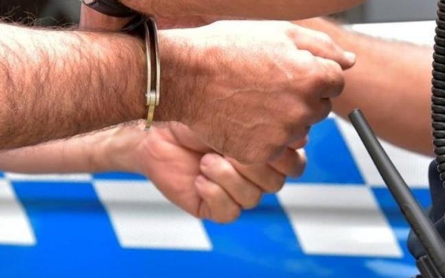 Imagen de archivo de un policía colocándole unas esposas a una persona. Imagen de archivo de un policía colocándole unas esposas a una persona.