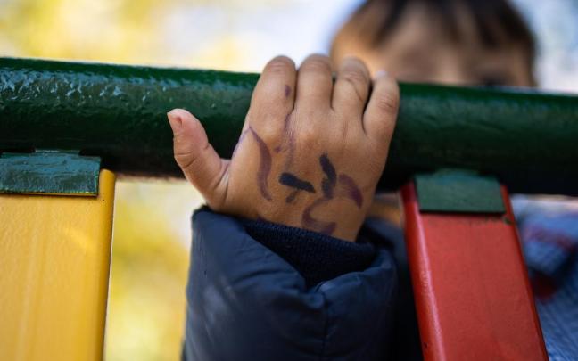Un niño juega en unos columpios. Un niño juega en unos columpios.