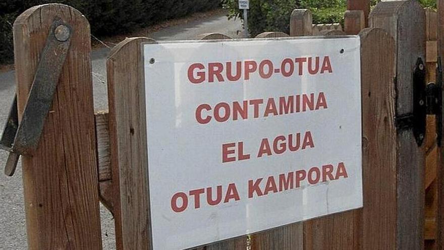 Cartel de denuncia de contaminación de aguas colocada en el exterior de instalaciones industriales junto a Urrunaga.