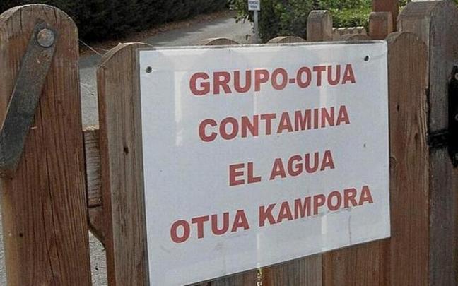 Cartel de denuncia de contaminación de aguas colocada en el exterior de instalaciones industriales junto a Urrunaga.