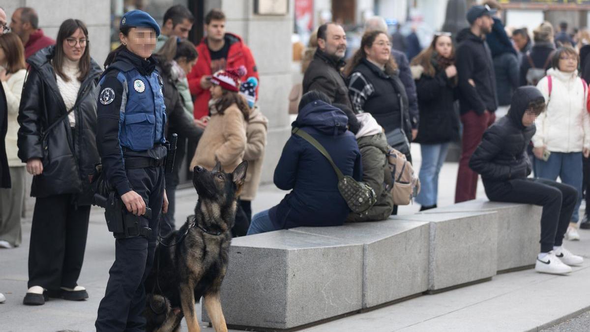 Un perro mira a una agente de la policía madrileña.