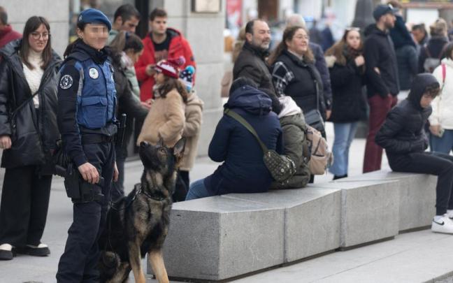 Un perro mira a una agente de la polic&iacute;a madrile&ntilde;a.