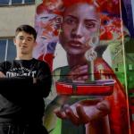 Nextor Ota&ntilde;o posa junto a su mural en una de las paredes de la Casa Ciriza de Trintxerpe.