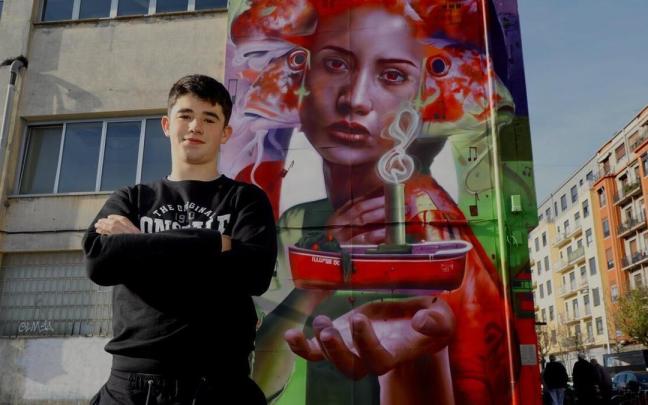 Nextor Otaño posa junto a su mural en una de las paredes de la Casa Ciriza de Trintxerpe.
