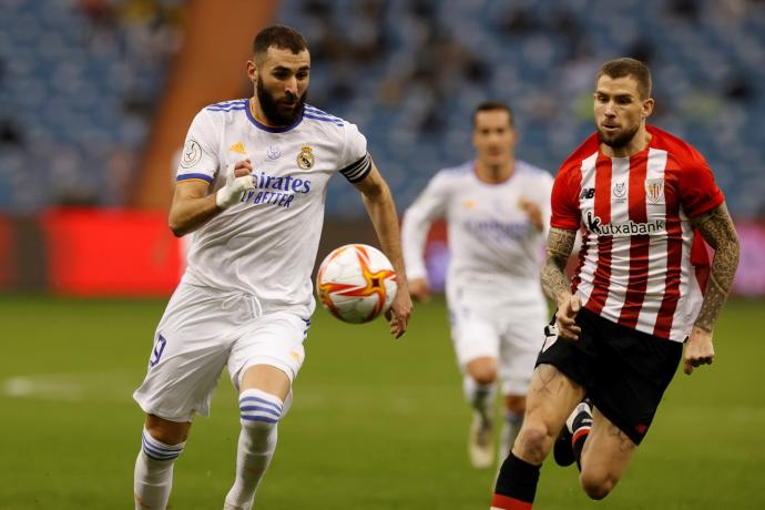 Karim Benzema trata de controlar un balón ante la mirada de Iñigo Martínez.