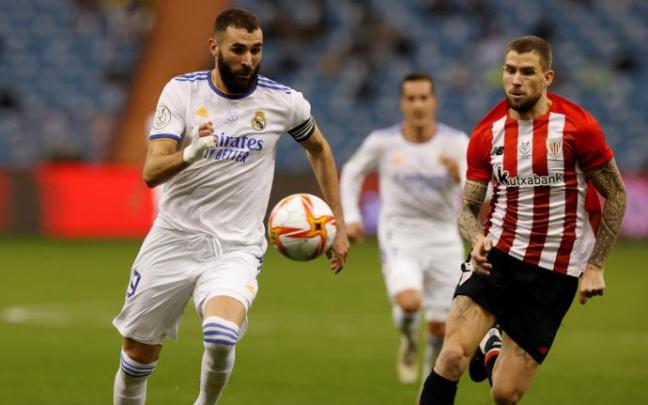 Karim Benzema trata de controlar un balón ante la mirada de Iñigo Martínez.
