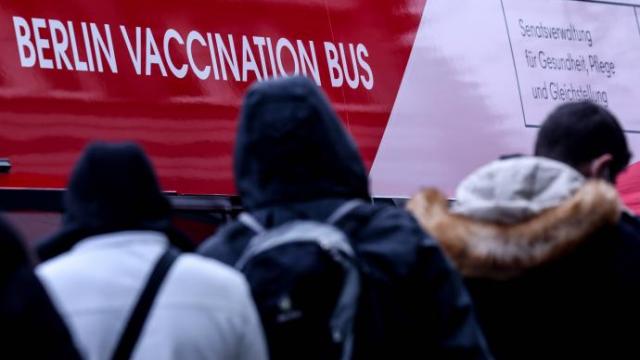 Varias personas hacen cola para vacunarse en el interior de un autobús itinerante en Berlín.