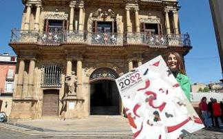 La joven pamplonesa Olaia Merino Erviti posa con el cartel de Sanfermines 2022 en la plaza Consistorial minutos antes de las 12 del mediodía.