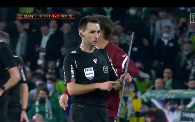 El árbitro con el palo lanzado.