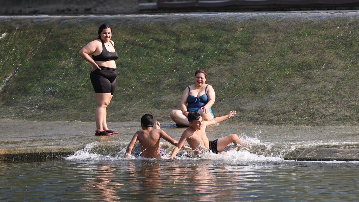 Una familia se refresca en el río ante las altas temperaturas.