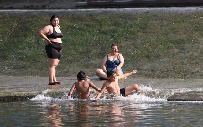 Una familia se refresca en el río ante las altas temperaturas.