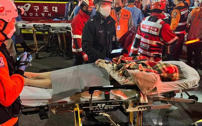 Equipos de emergencia atienden a personas heridas tras la estampida en una fiesta de Halloween