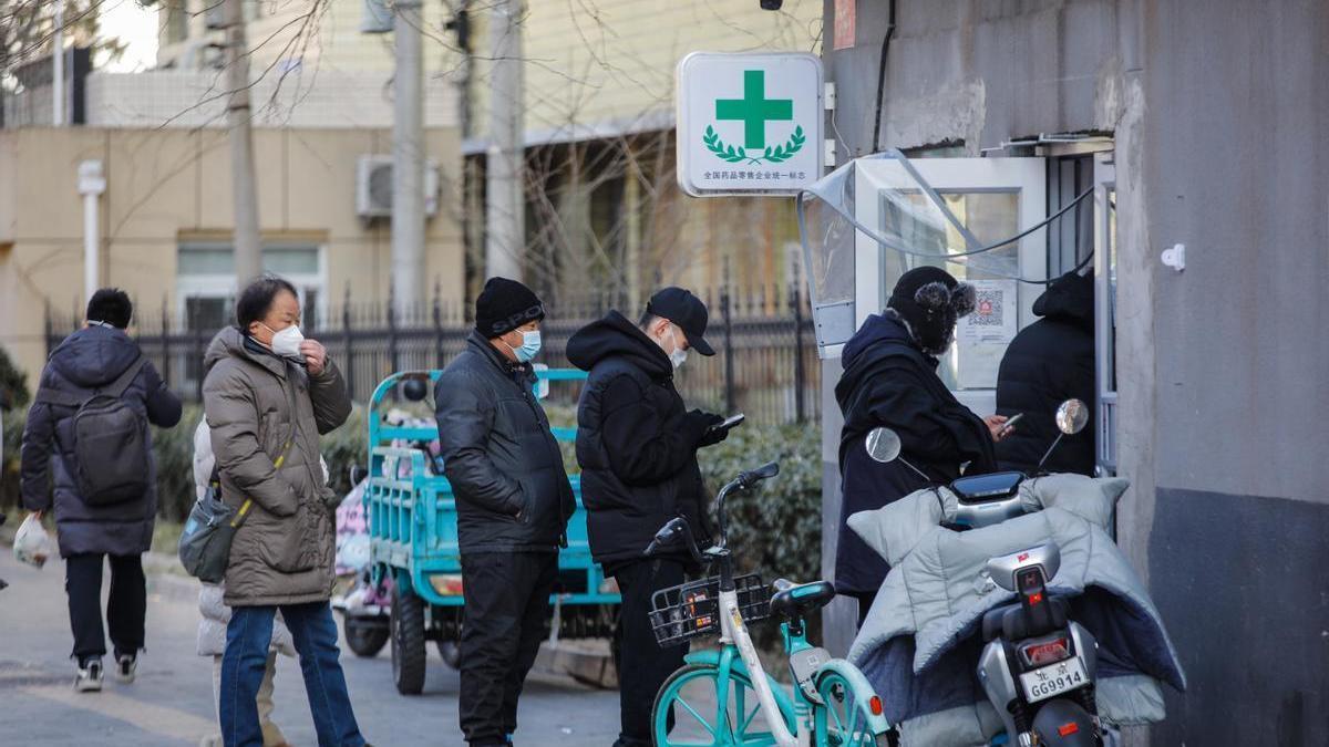 Varias personas hacen cola para comprar medicinas en una farmacia de Pekín.