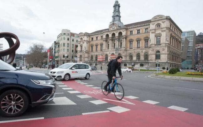 Un hombre pasa cerca del Ayuntamiento de Bibao en bicicleta