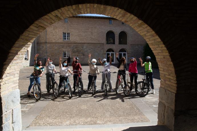 Nueve integrantes de la 'Biciescuela para personas adultas' posan con los brazos levantados en el interior del Museo de Educación Ambiental.