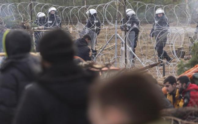 Soldados polacos vigilan a los refugiados desde el otro lado de la frontera Soldados polacos vigilan a los refugiados desde el otro lado de la frontera