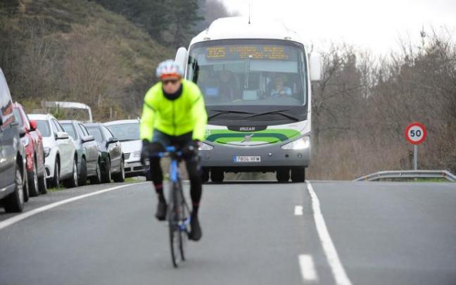 Un ciclista circula delante de una unidad de Bizkaibus Un ciclista circula delante de una unidad de Bizkaibus