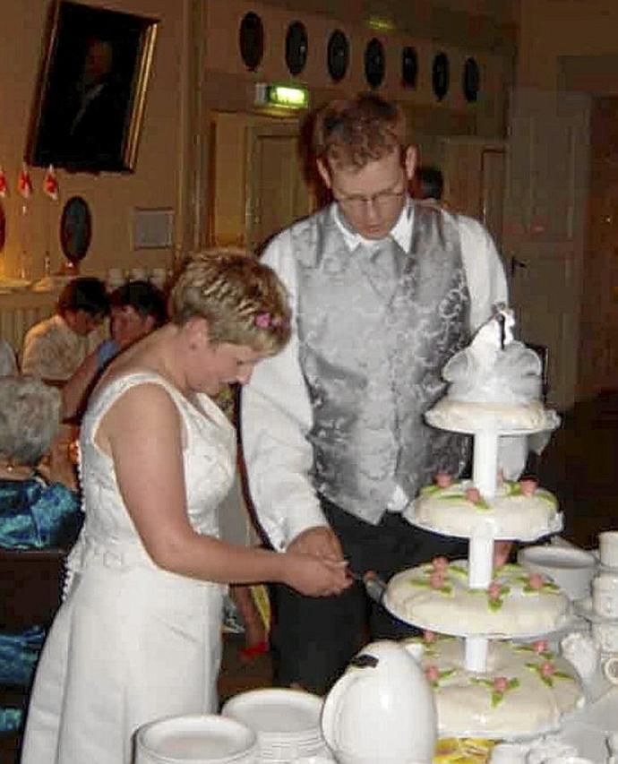 Una pareja de recién casados corta la tarta de boda. Foto: DNA