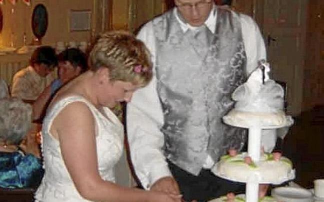 Una pareja de recién casados corta la tarta de boda. Foto: DNA