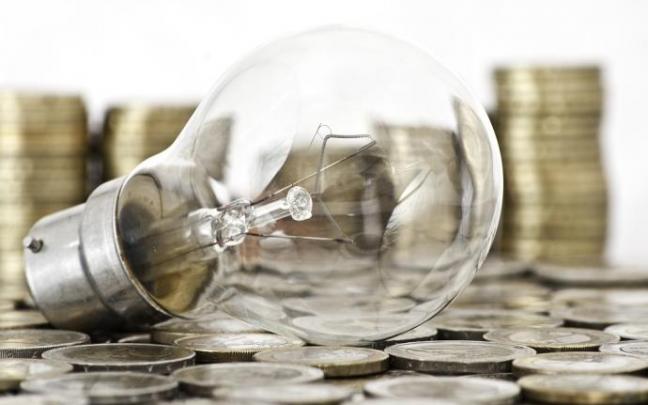 Imagen de una bombilla sobre monedas de euros. Imagen de una bombilla sobre monedas de euros.