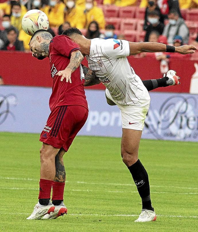 Rubén García y Diego Carlos intentan golpear el balón con la cabeza.