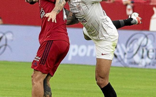 Rubén García y Diego Carlos intentan golpear el balón con la cabeza.