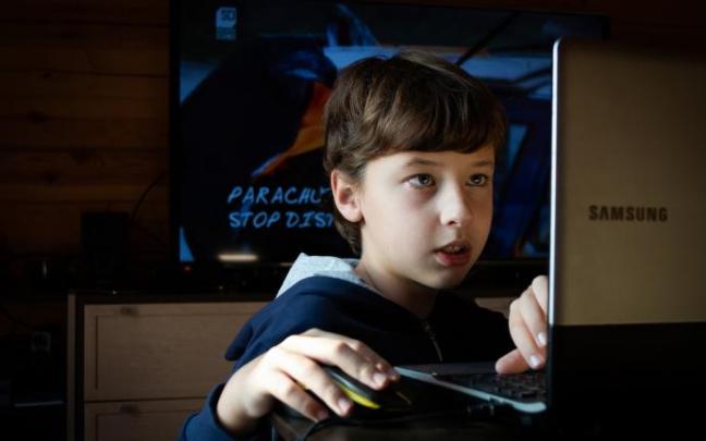 Un niño permanece completamente concentrado ante la pantalla de juego. Un niño permanece completamente concentrado ante la pantalla de juego.