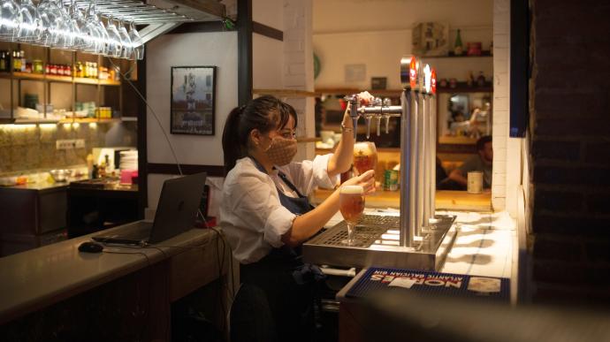 Imagen de archivo de una camarera trabajando en la barra de un bar en plena sexta ola de pandemia del coronavirus.