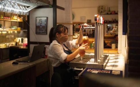 Imagen de archivo de una camarera trabajando en la barra de un bar en plena sexta ola de pandemia del coronavirus.