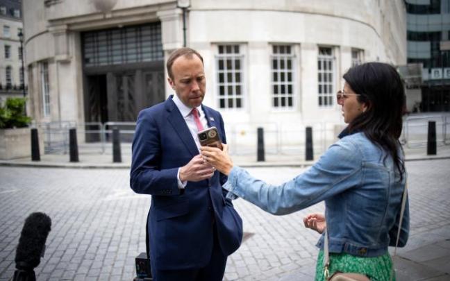 Matt Hancock observa la portada del diario 'The Sun', donde aparecía junto a su ayudante