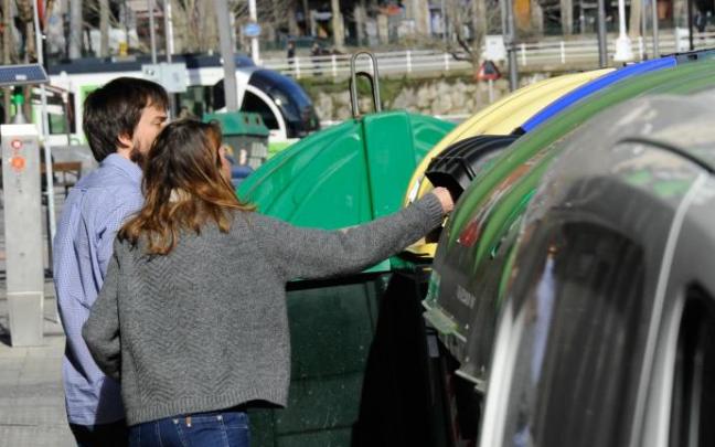 Dos jóvenes depositan basura en varios contenedores de Bilbao
