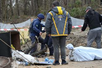 Los servicios de rescate sacan el cuerpo de un hombre de una fosa común en Buzova.