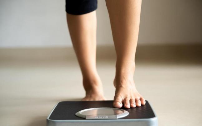 Una mujer sube a una b&aacute;scula para un control de peso.