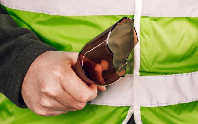 Imagen de un hombre con una botella rota