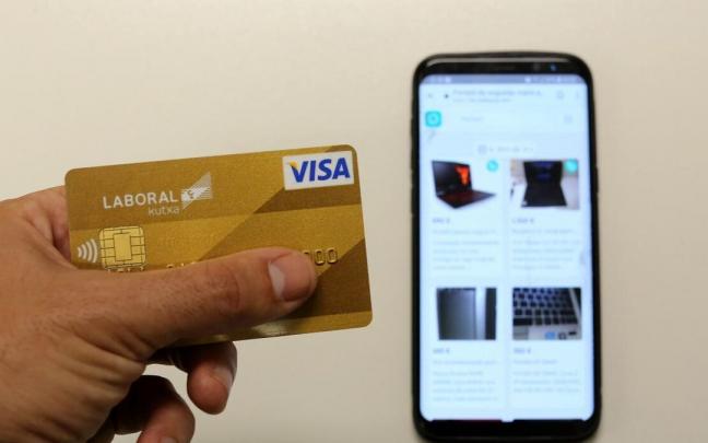 Un joven hace compras 'online' con su móvil. Un joven hace compras 'online' con su móvil.