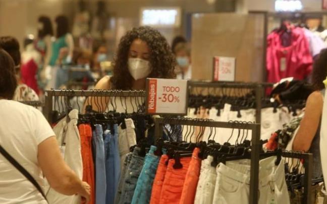 Dos mujeres miran las prendas en una tienda de ropa. Dos mujeres miran las prendas en una tienda de ropa.