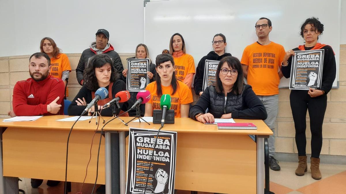 Rub&eacute;n Ramallo (CCOO), N&uacute;ria Velasco (ELA), Tamara Angulo (LAB) y Sera Alonso (UGT), acompa&ntilde;ados por empleados y empleadas de gesti&oacute;n deportiva.