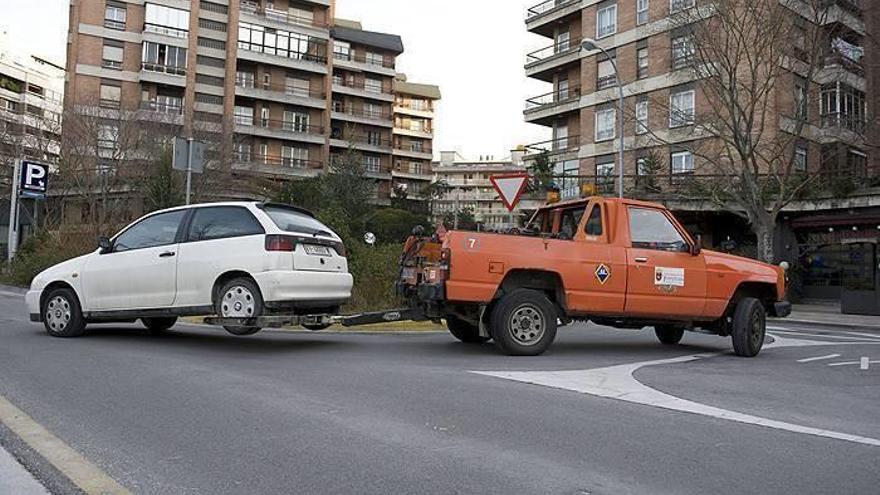 Una grúa lleva un vehículo al depósito municipal.