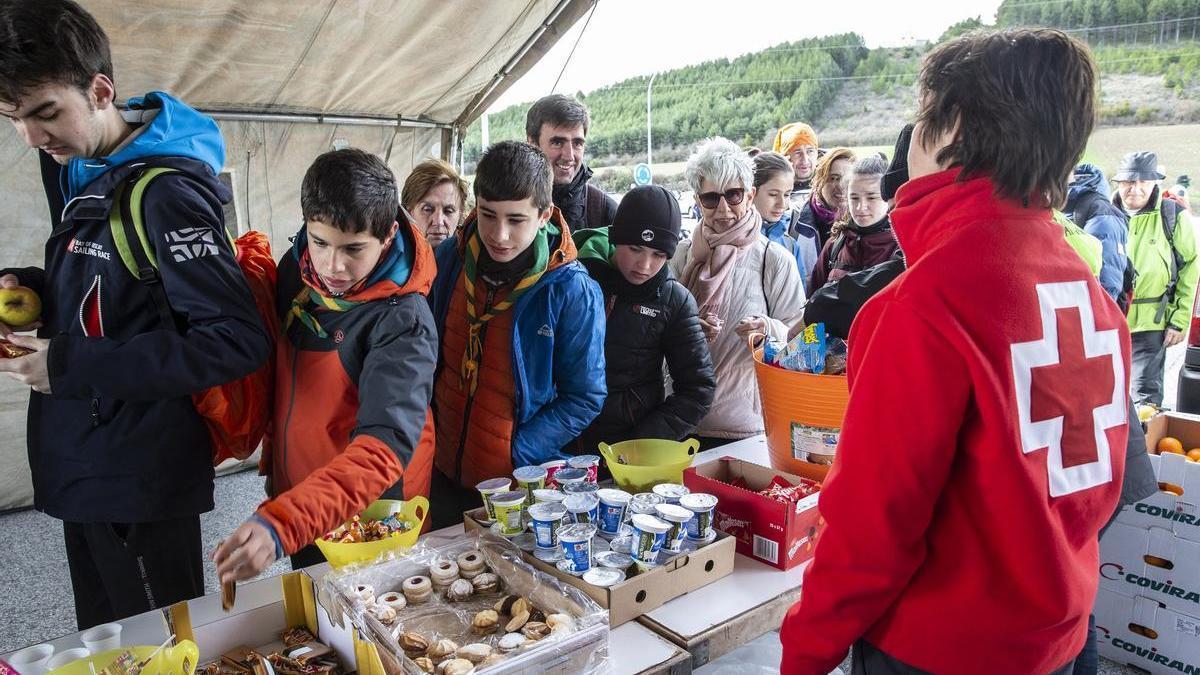 Varios peregrinos cogen comida en el puesto de avituallamiento de La Venta de Judas, en la primera Javierada de 2020.