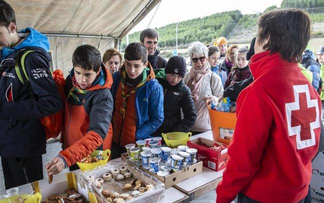 Varios peregrinos cogen comida en el puesto de avituallamiento de La Venta de Judas, en la primera Javierada de 2020.