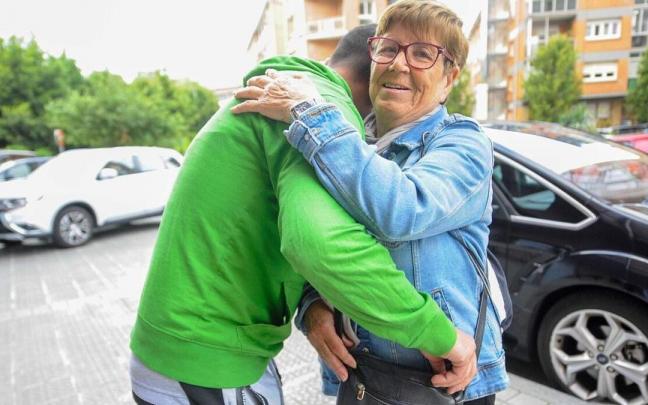 Una mujer recibe el abrazo de un joven en la vía pública. Una mujer recibe el abrazo de un joven en la vía pública.